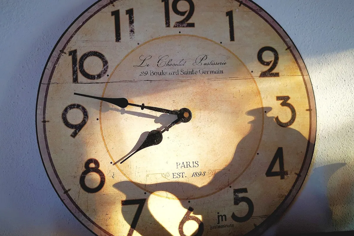 Reloj de pared analógico iluminado por la luz de la mañana