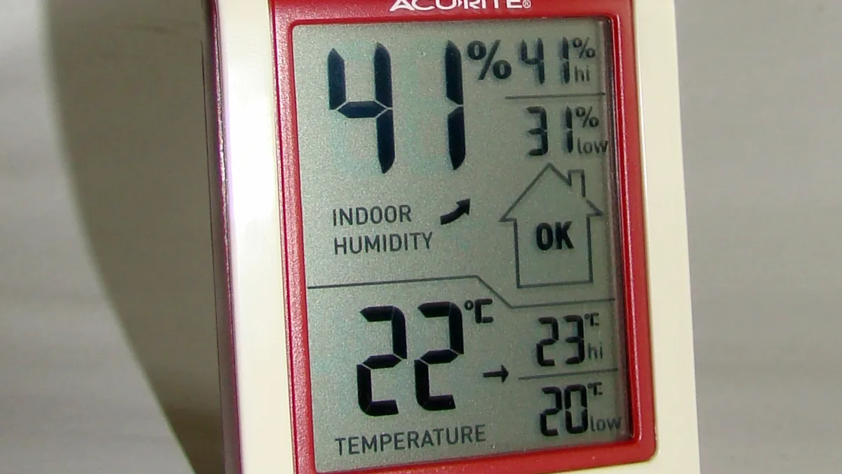 Termohigrómetro digital mostrando la humedad y la temperatura interior de una casa